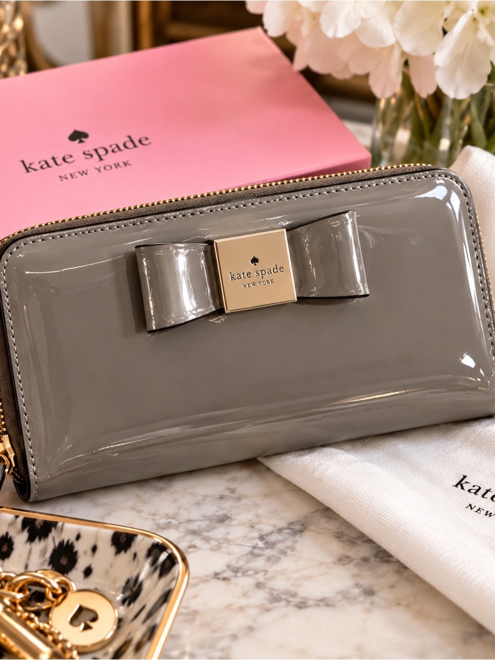 kate spade gray patent bow zip-around wallet with gold plaque